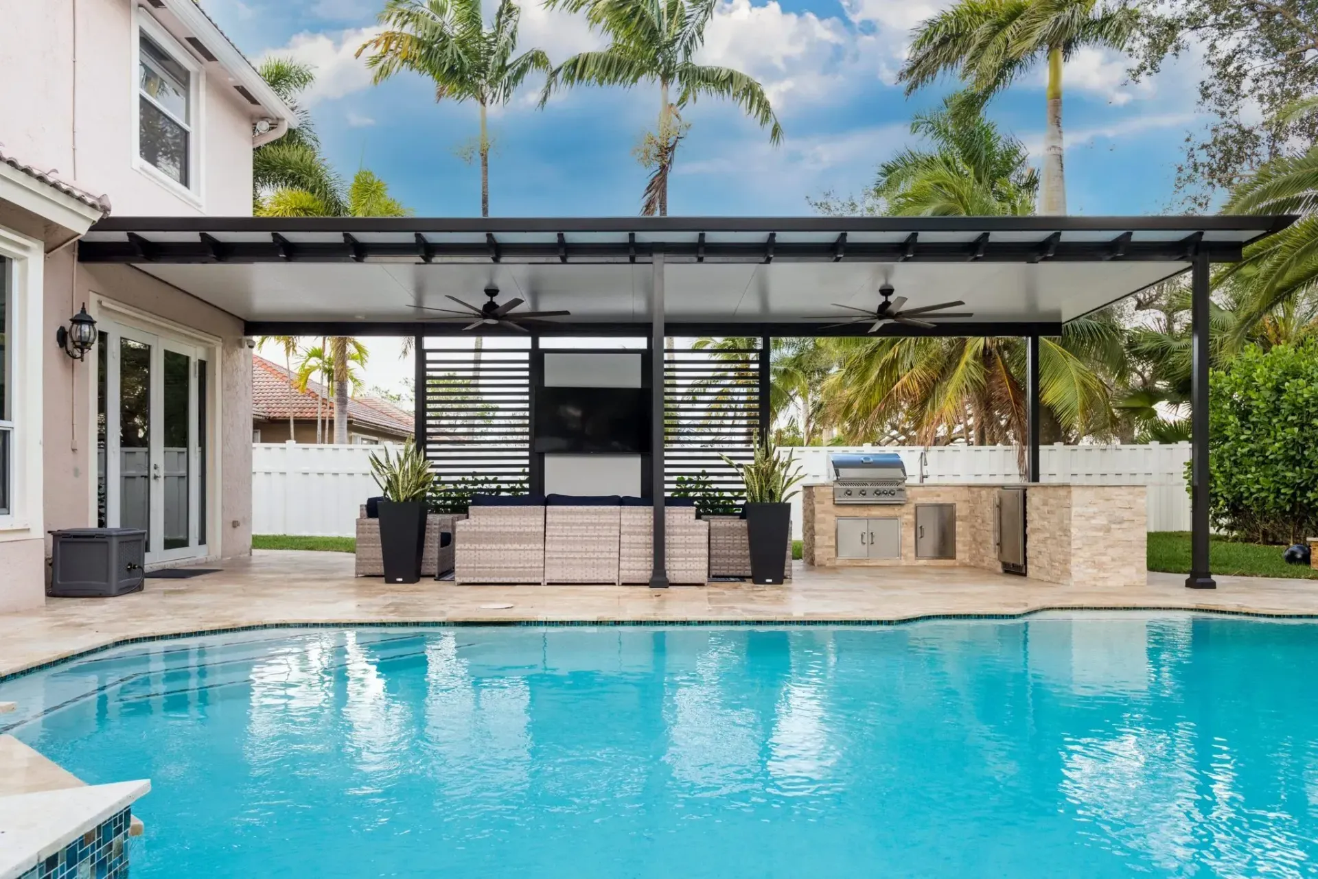 Modern backyard with turquoise swimming pool, covered patio, and outdoor seating under a glass roof