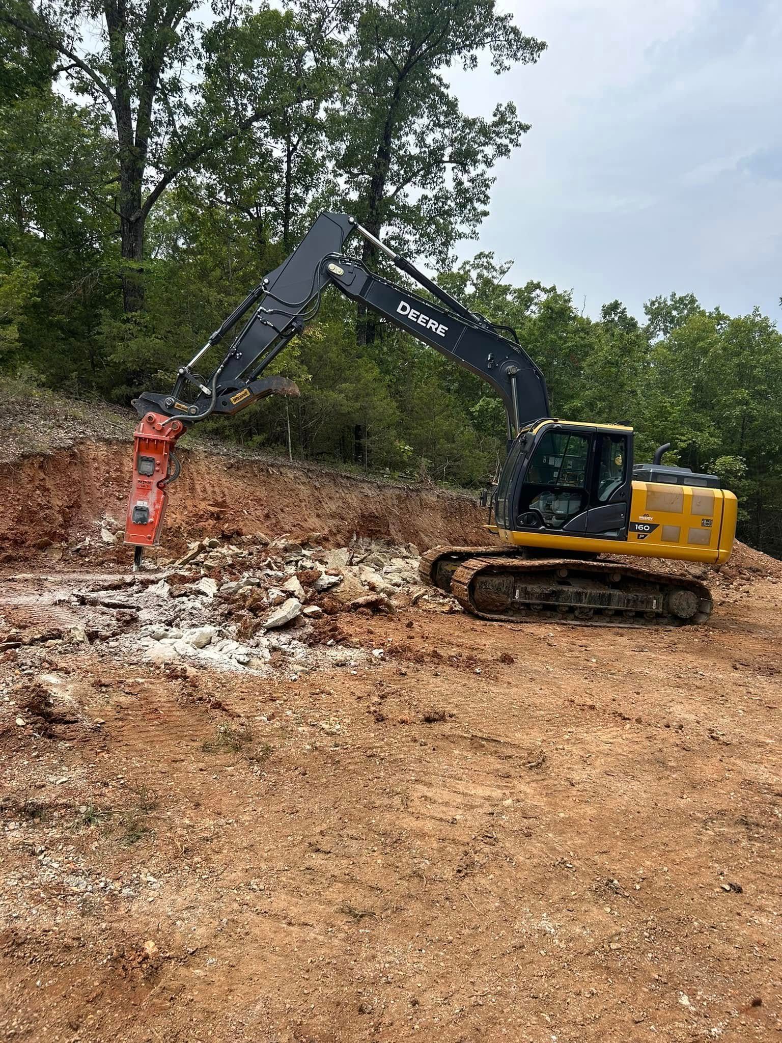 Woman in straw hat smiles, holding wine glass near a lake.