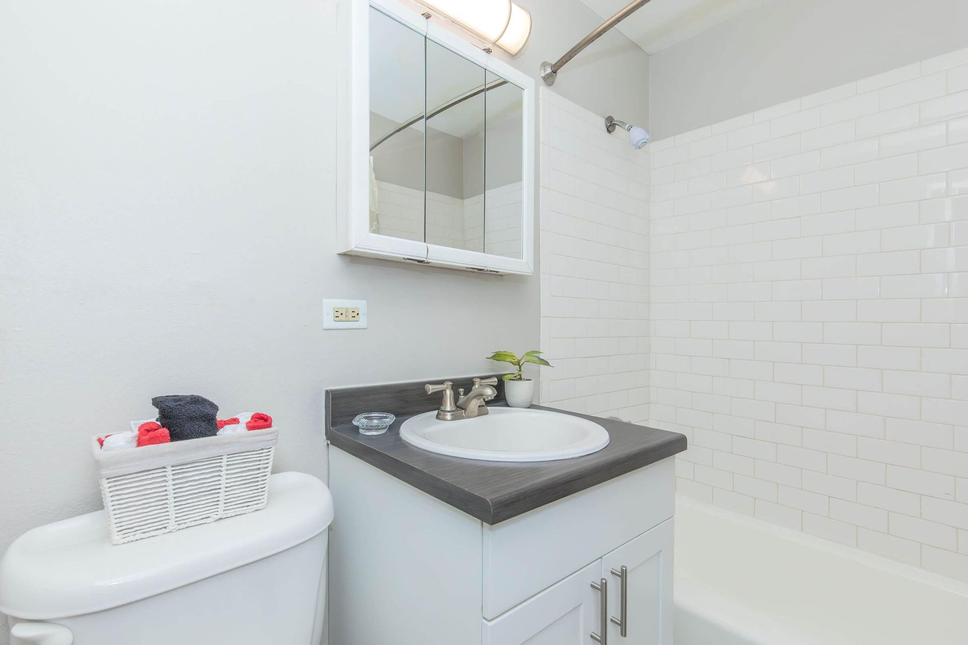 Bathroom with white walls, a sink, toilet, and a bathtub.
