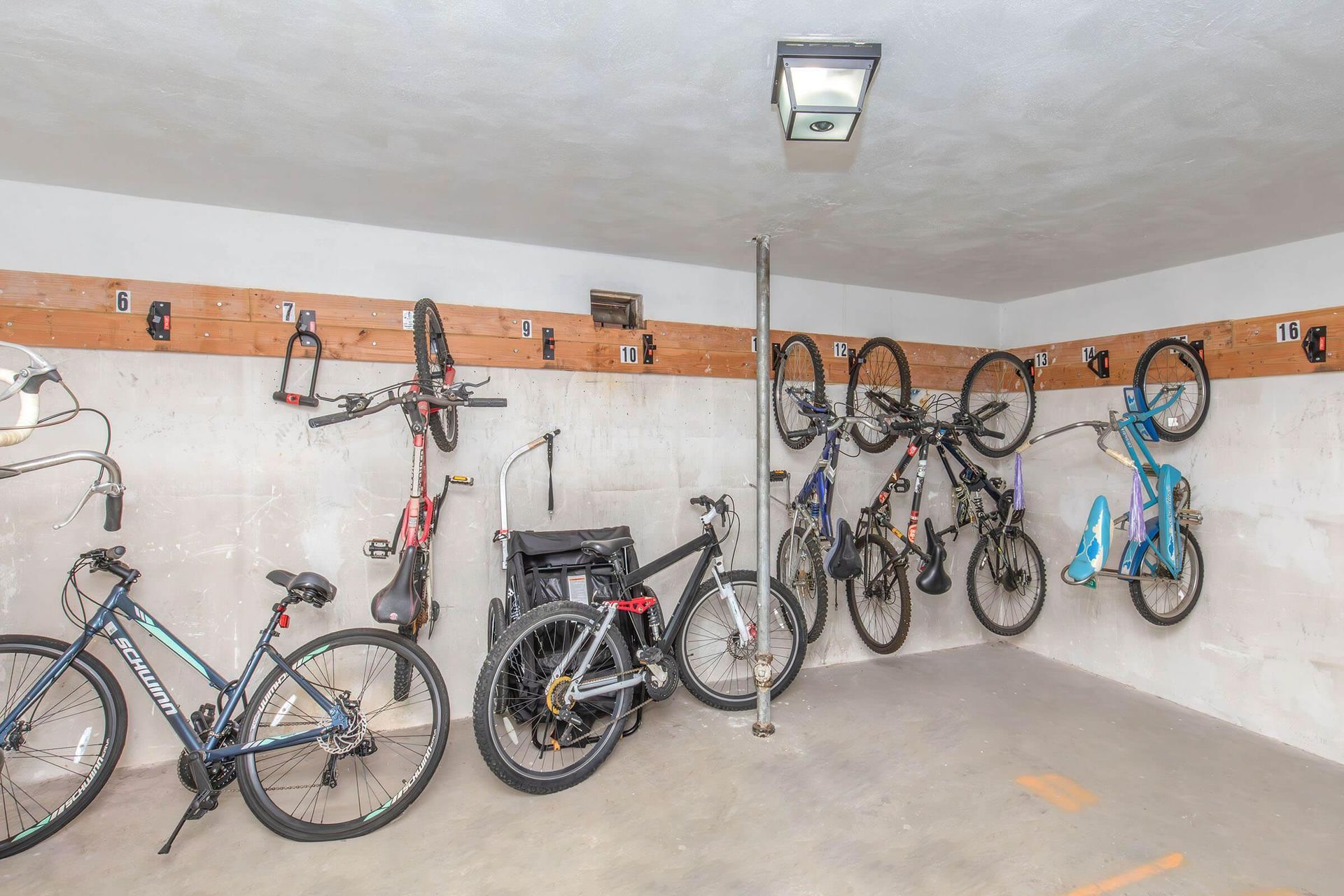 Garage with bicycles stored on the wall using hooks.