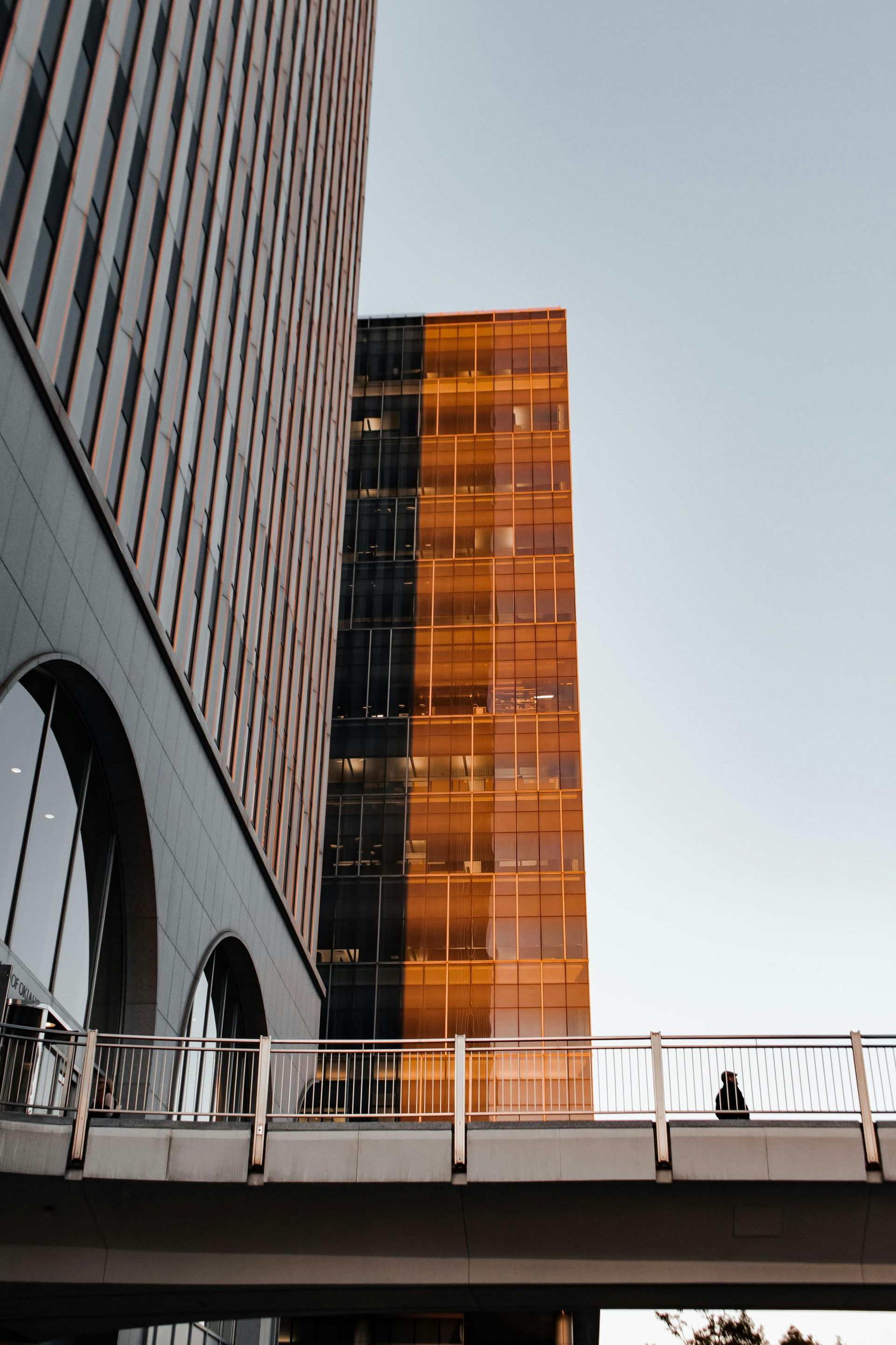 Large beige and red multi-story building with many windows under a cloudy sky.