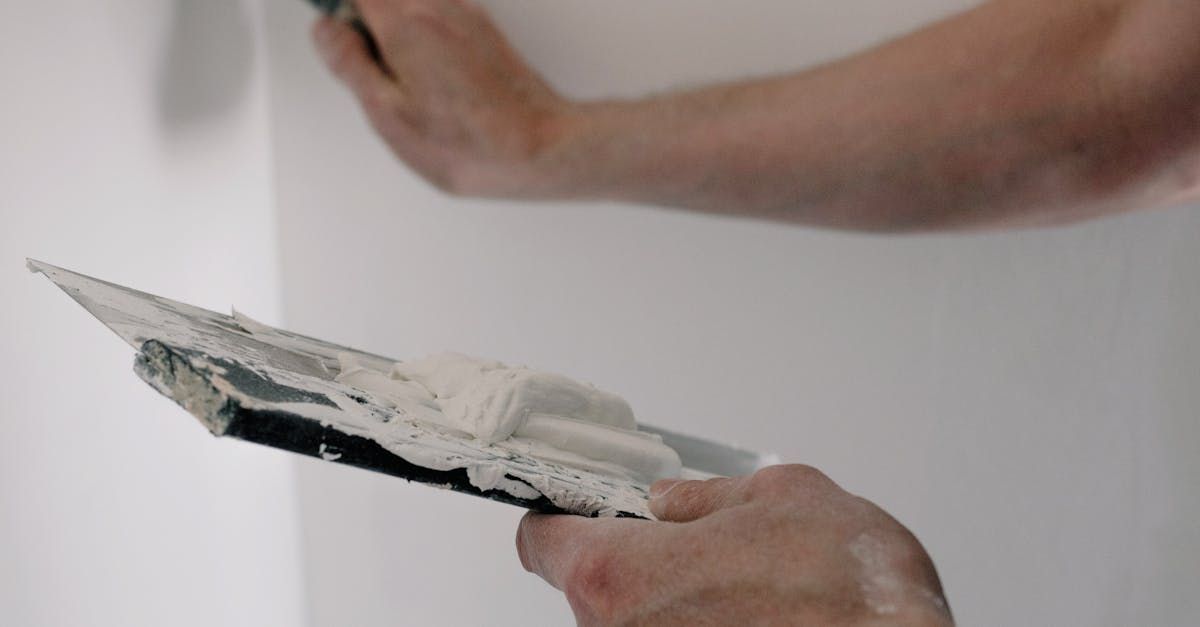 A person is plastering a wall with a spatula.