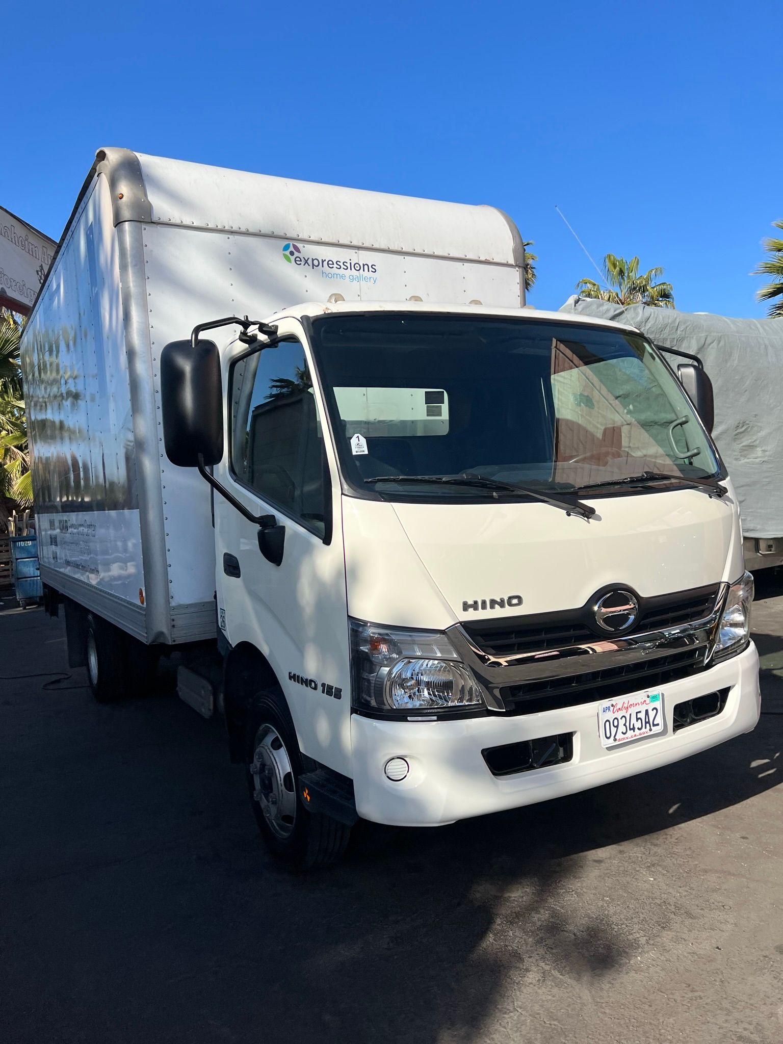 A close up of a car suspension with a tire in the background.