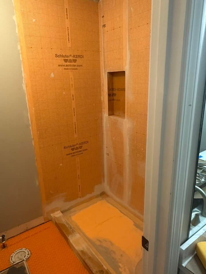 A shower stall is being built in a bathroom.