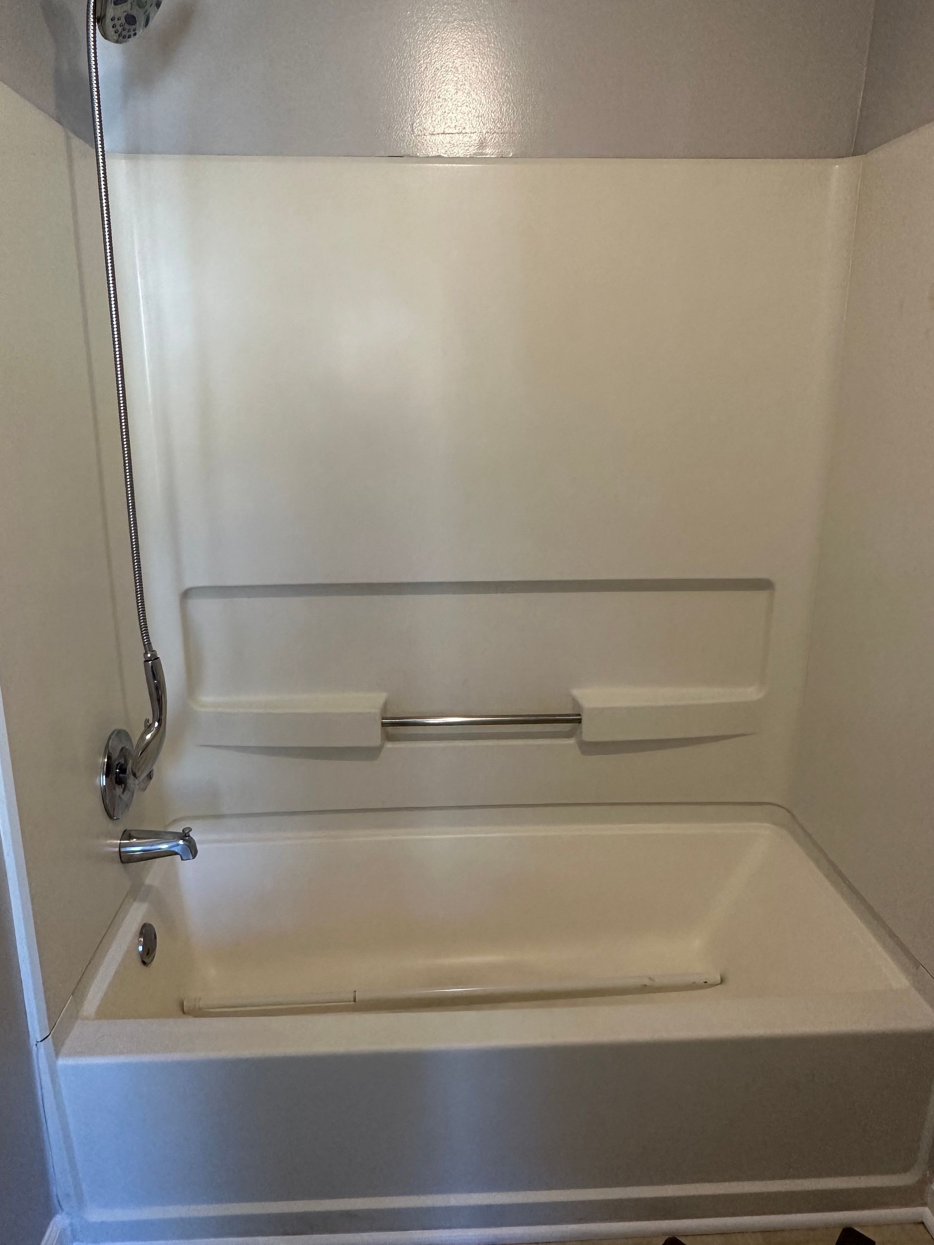 A bathtub is sitting in a bathroom next to a shower.