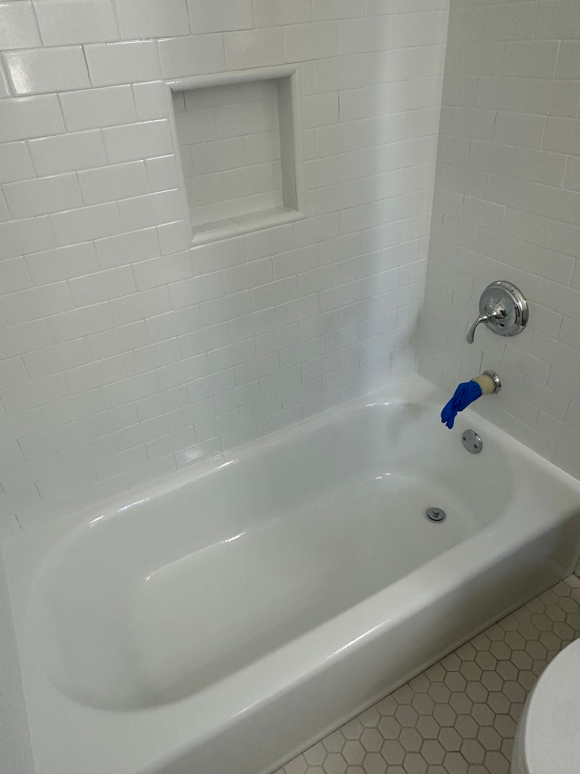 A white bathtub in a bathroom next to a toilet.