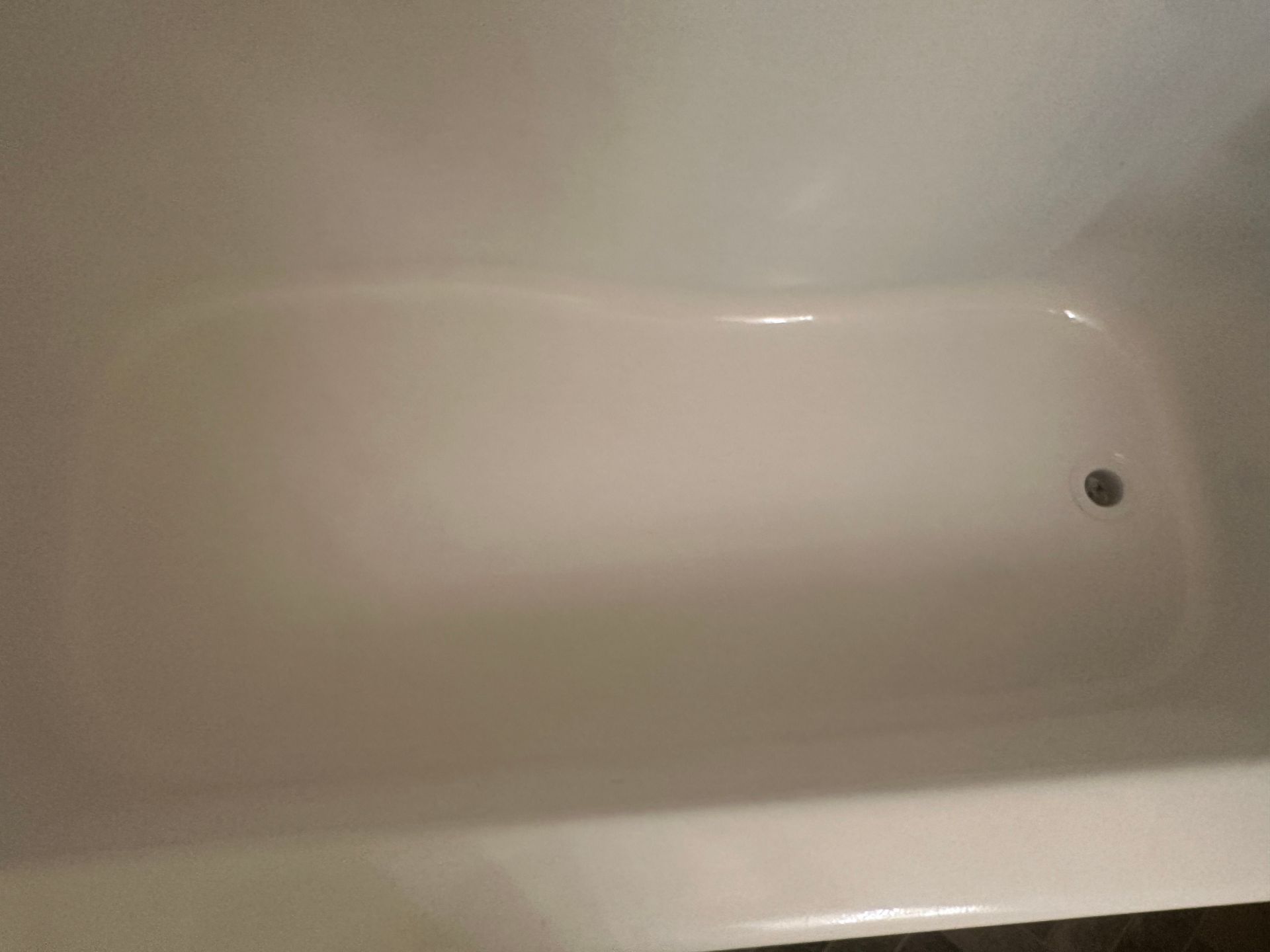A white bathtub with a hole in the middle of it.