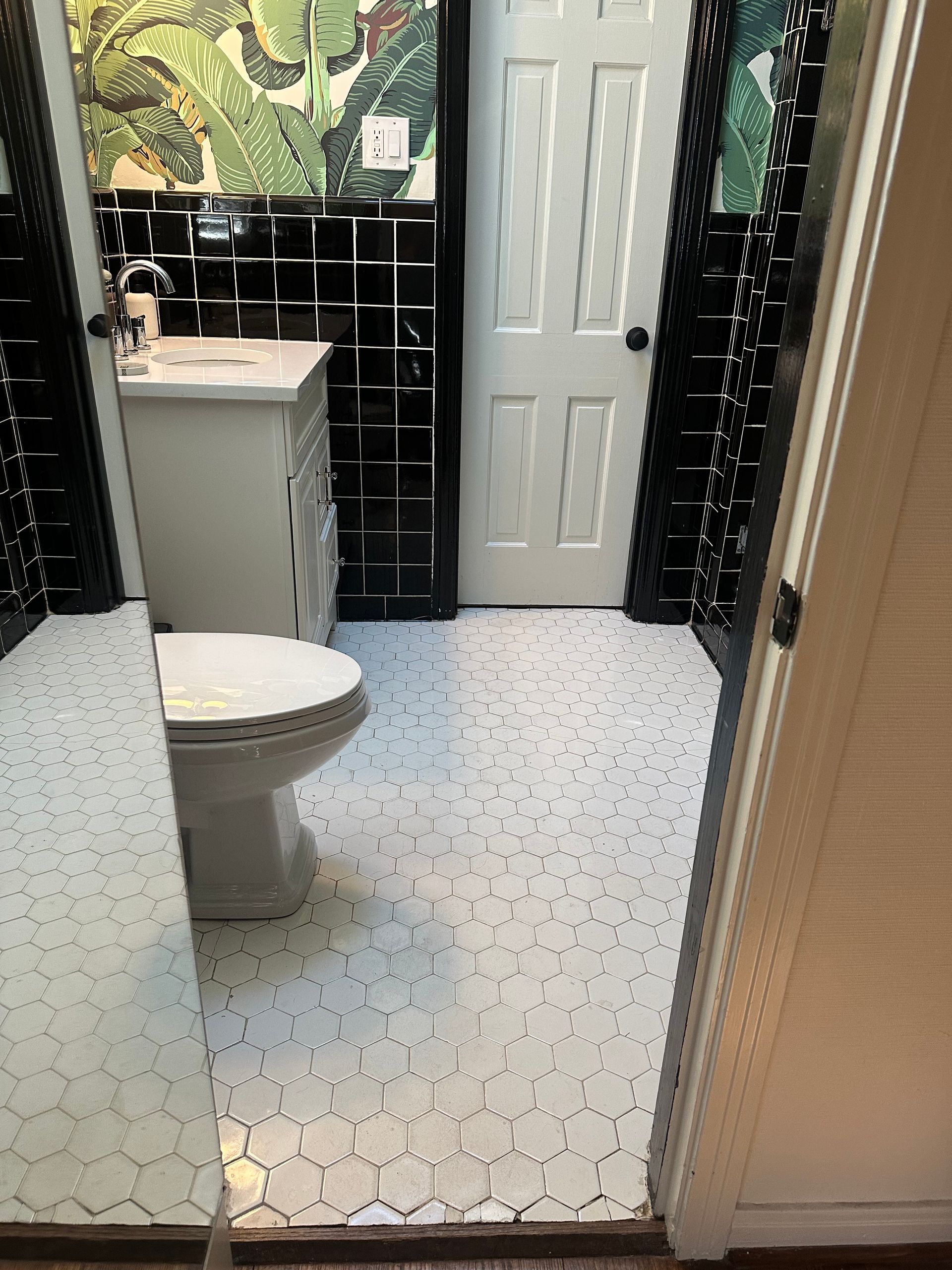 A bathroom with a toilet , sink and mirror.
