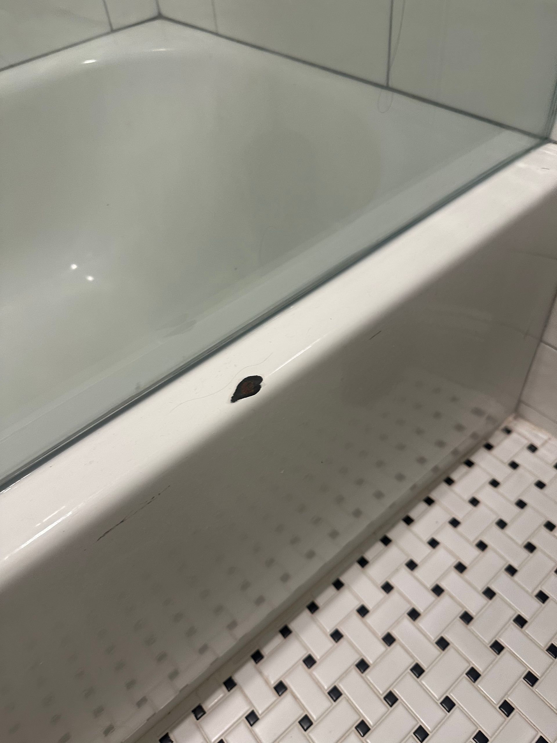 A bathtub with a hole in the side of it