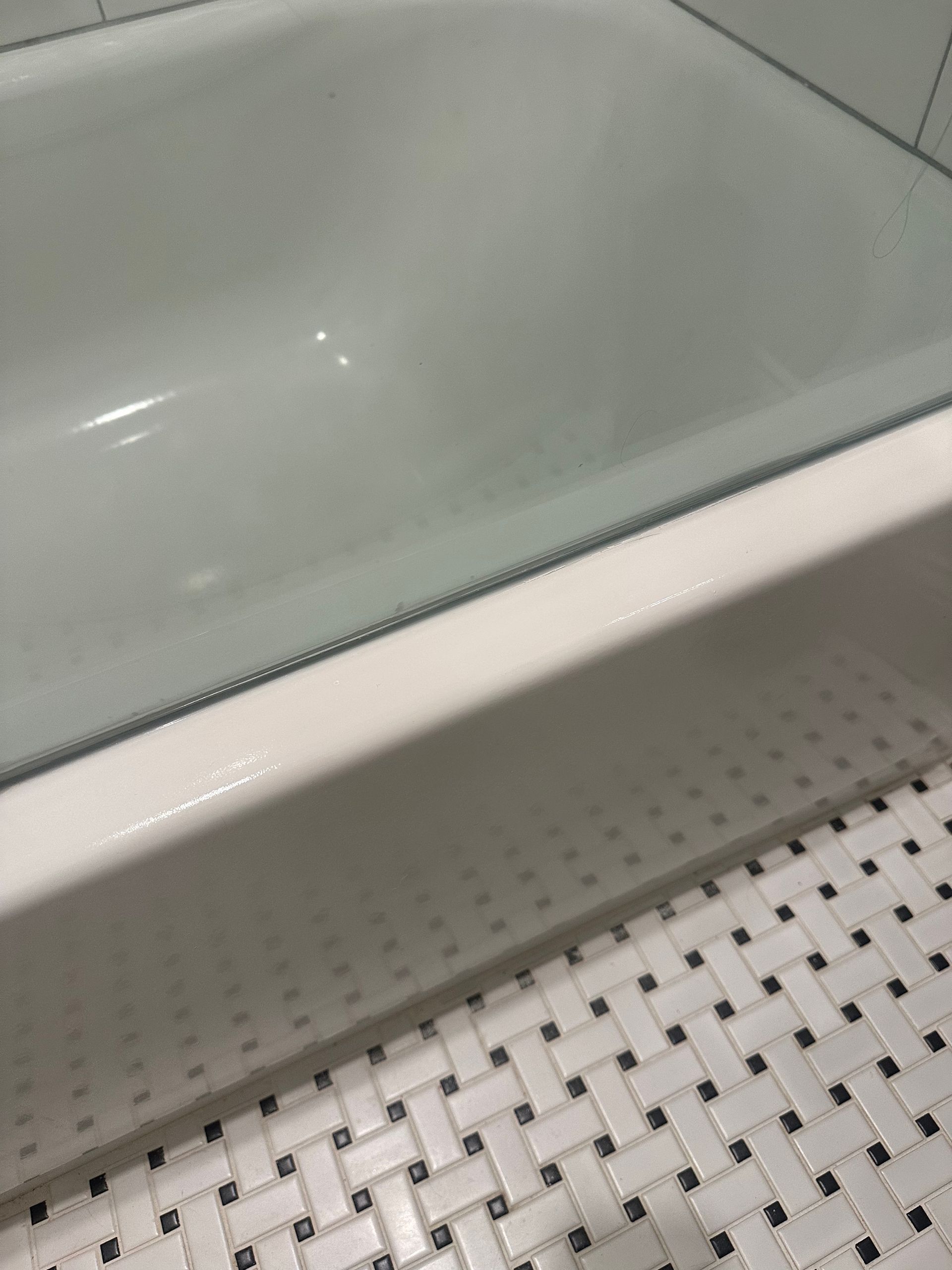 A bathtub is sitting on top of a tiled floor in a bathroom.