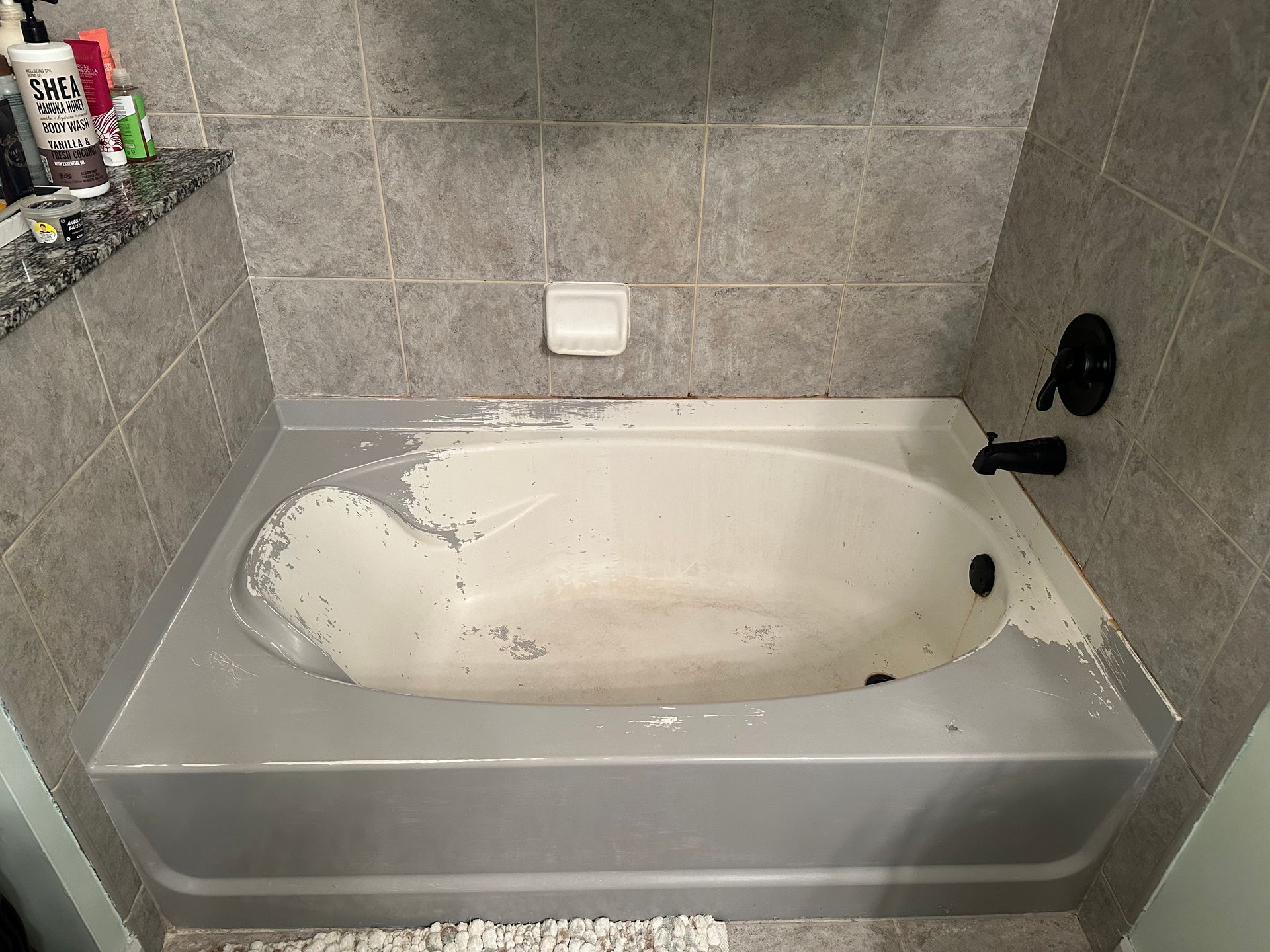 A bathtub in a bathroom that has been painted white.