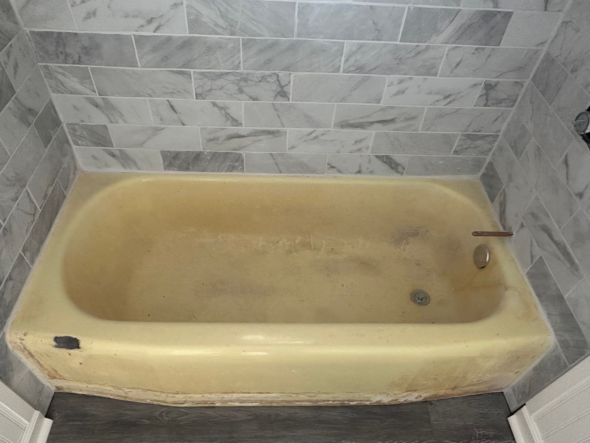 A white bathtub in a bathroom next to a toilet.