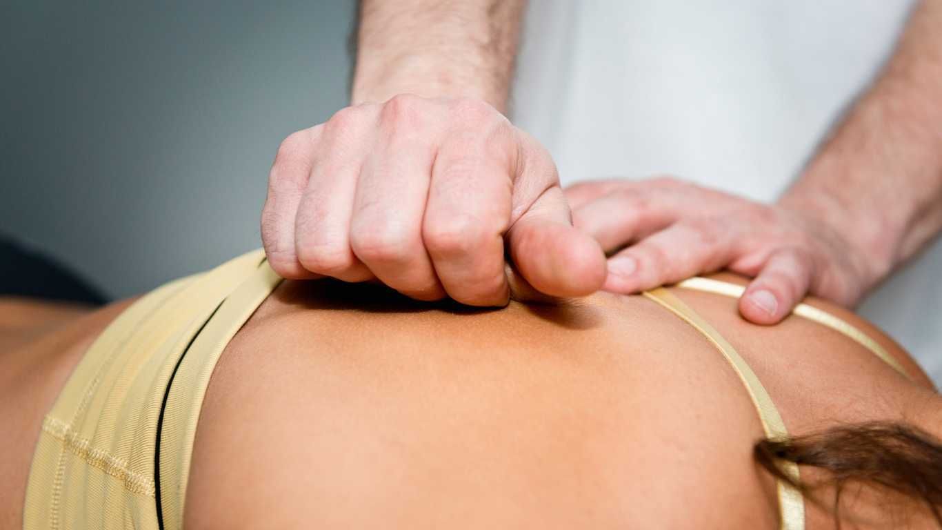 Chiropractic performing Myofascial Release therapy on a patient's back