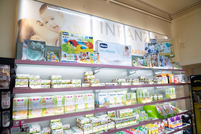 I prodotti per l'igiene orale Curasept sugli scaffali dei negozi, con etichette di confezionamento blu, bianche e viola.