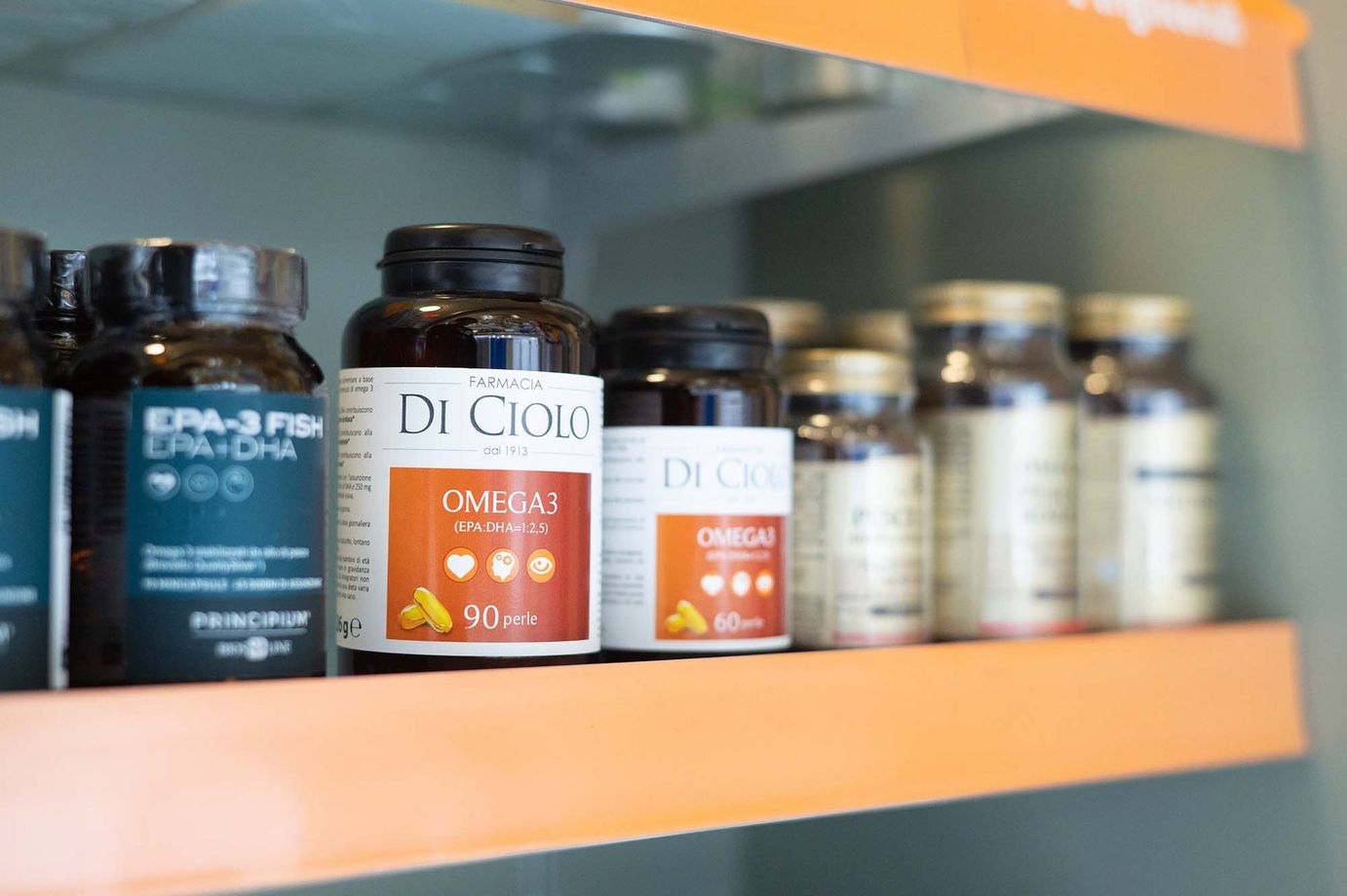 Le bottiglie di integratori alimentari Omega-3 sono disposte ordinatamente su uno scaffale del negozio.