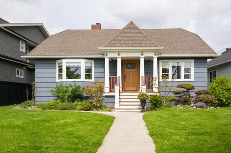 A blue house with a concrete walkway leading to it