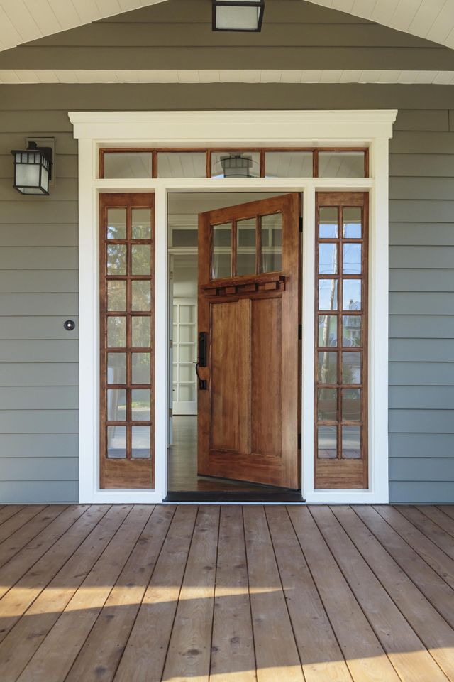 The front door of a house with a wooden deck