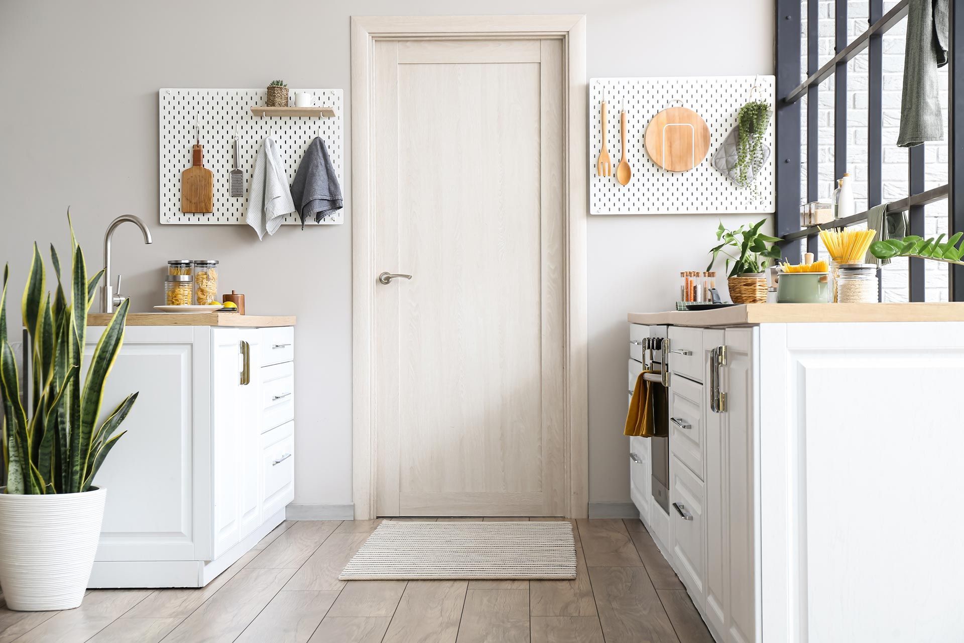 A kitchen with white cabinets and a white door.