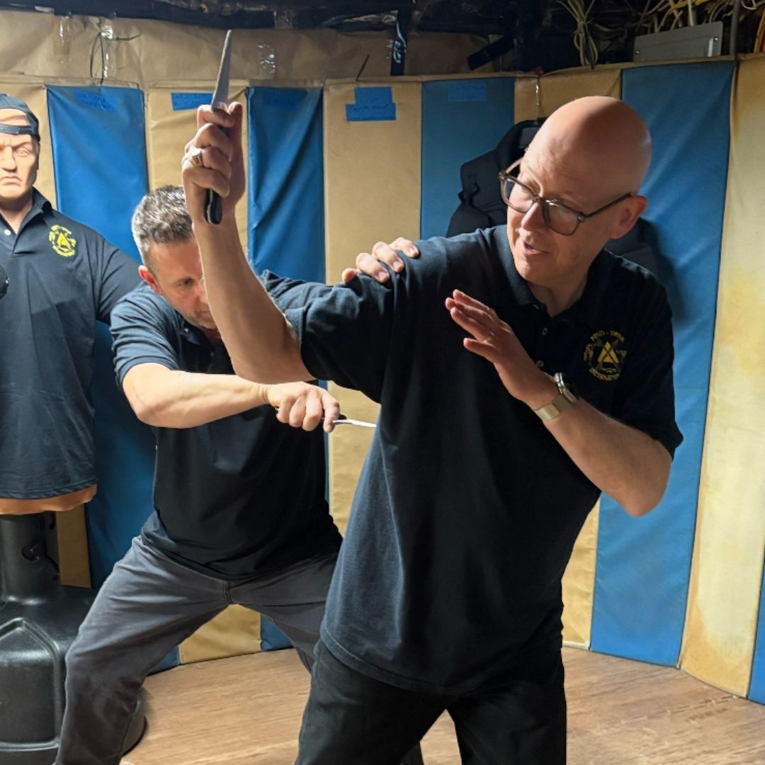 A woman is sitting on a bed with her head in her hands.
