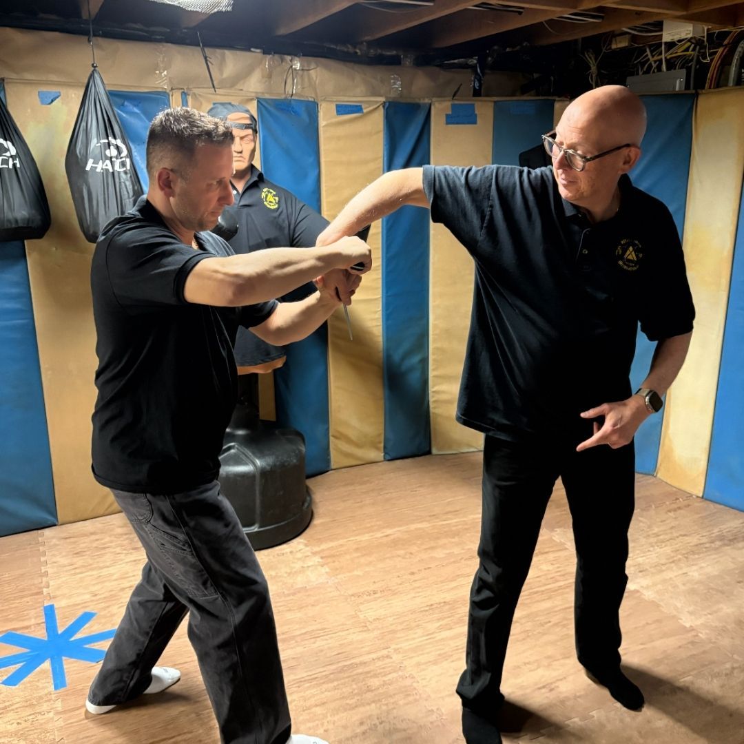 A brown puppy is laying on a bed looking at the camera.