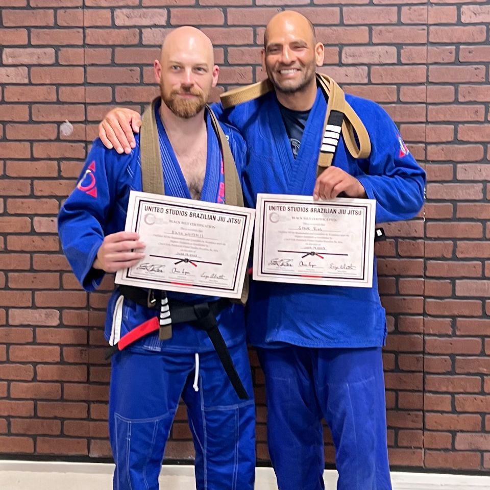 Two men standing next to each other holding certificates