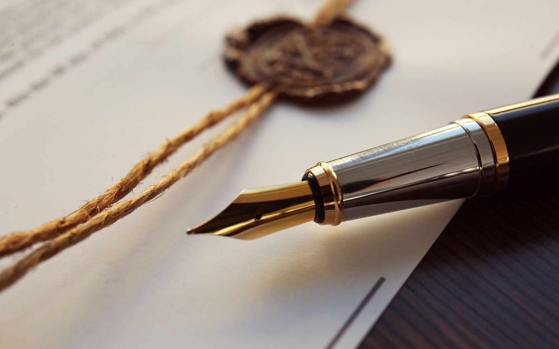 Fountain pen on a legal document with a wax seal, symbolizing a signed agreement.