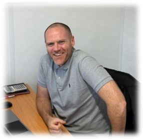 A man is sitting at a desk with a calculator on it.