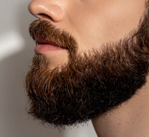 Homem exibindo contorno da barba perfeitamente desenhado e rosto sem foliculite após depilação a laser.