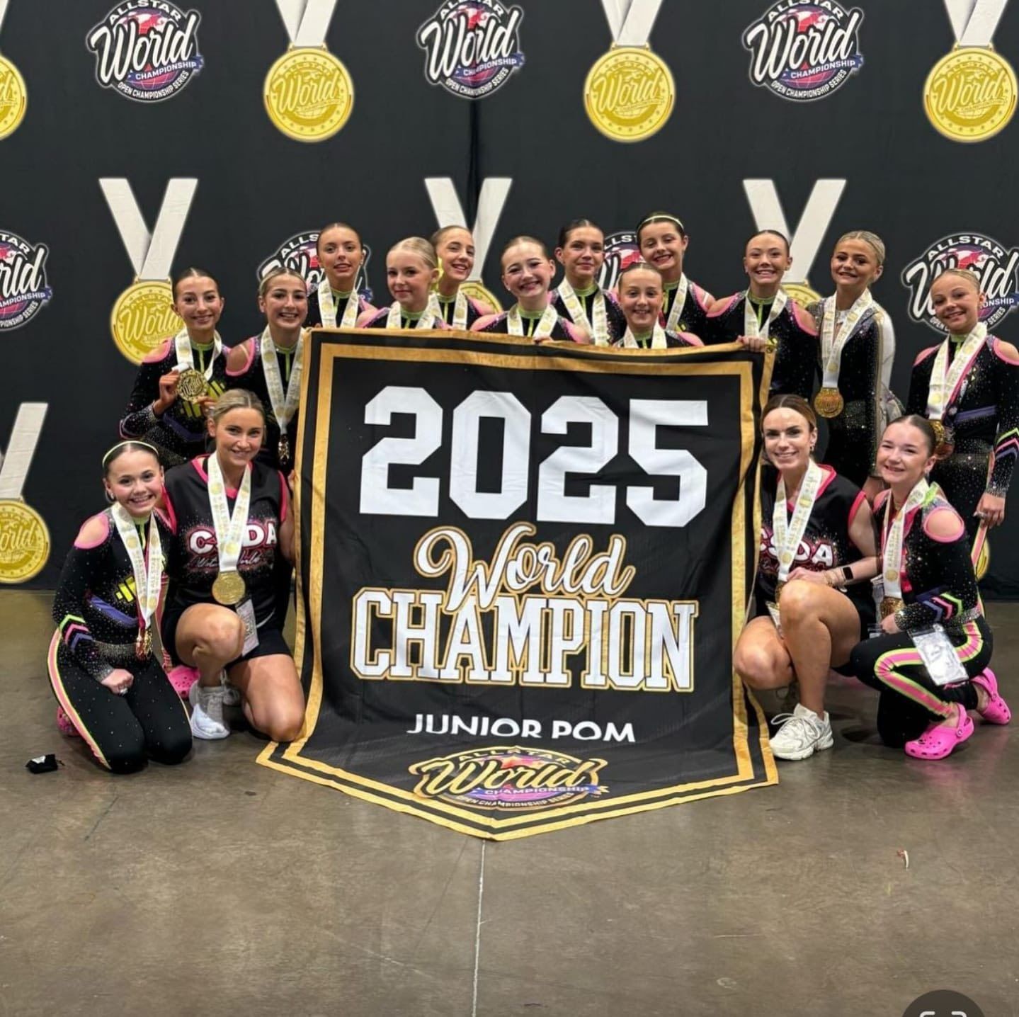 A group of girls holding a banner that says 2025 world champion