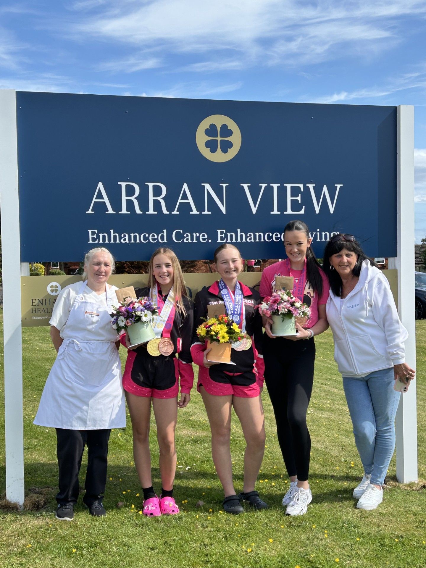 A group of people standing in front of a sign that says arran view.