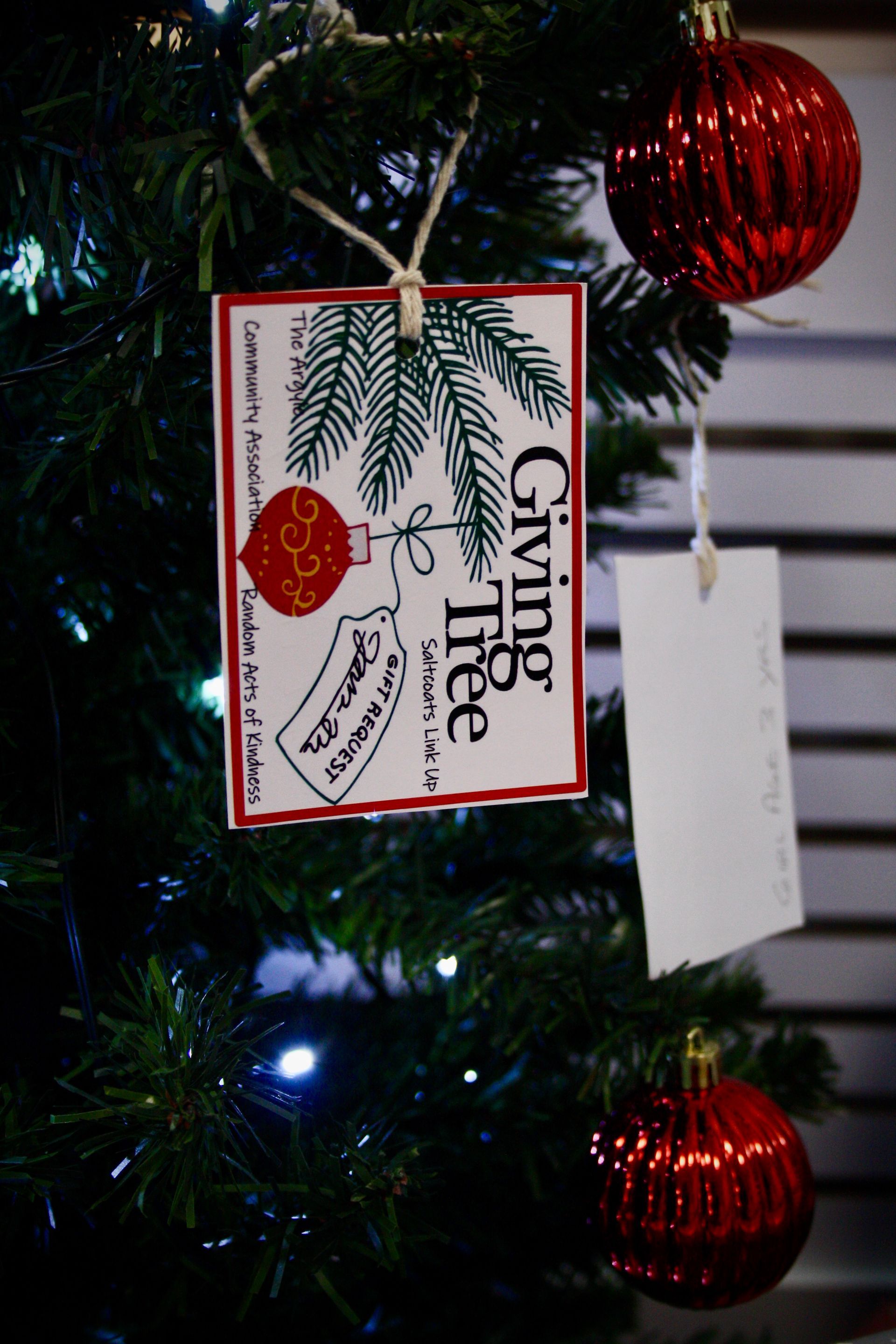 A christmas tree with a tag that says giving tree