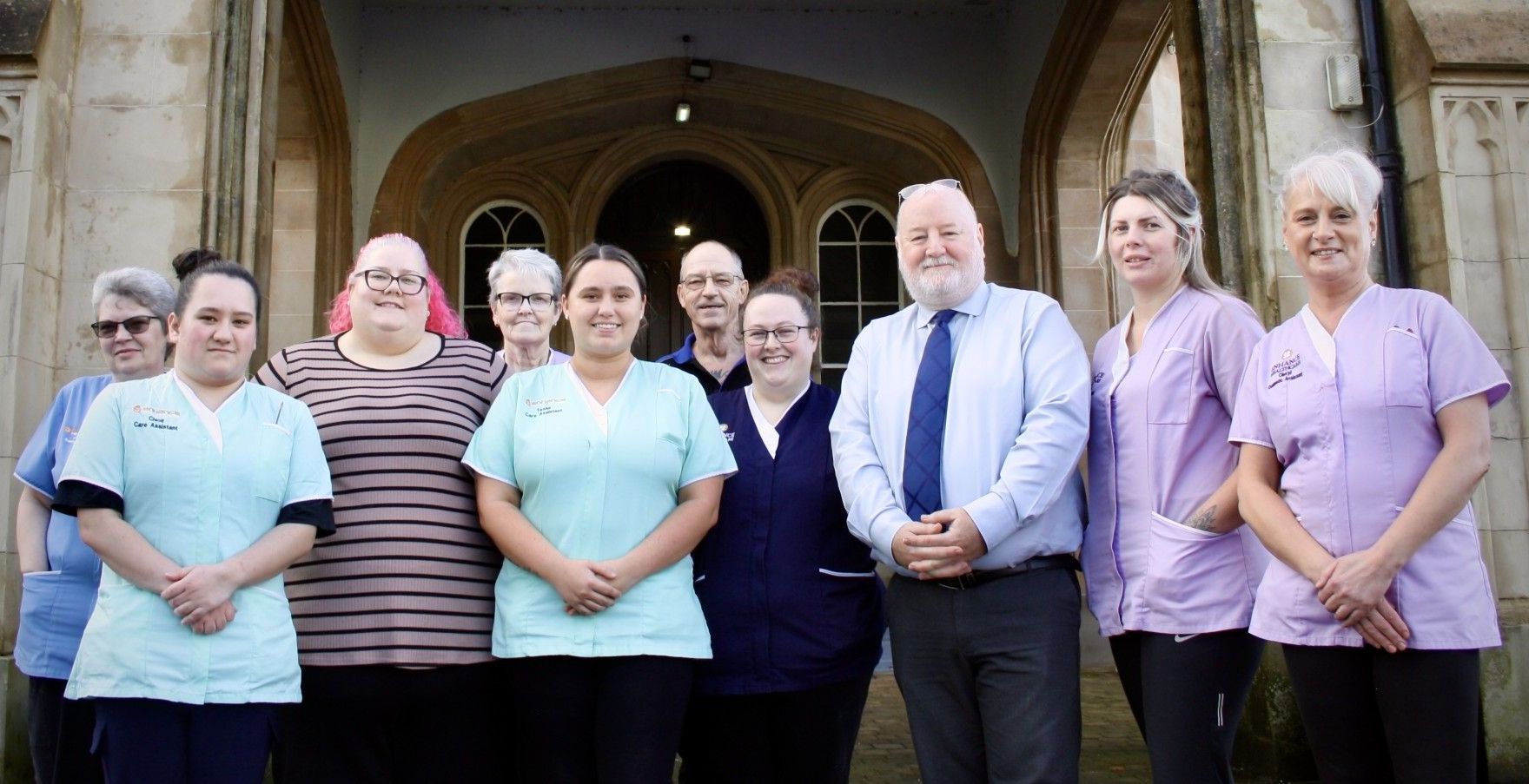 A group of people are posing for a picture in front of a building.