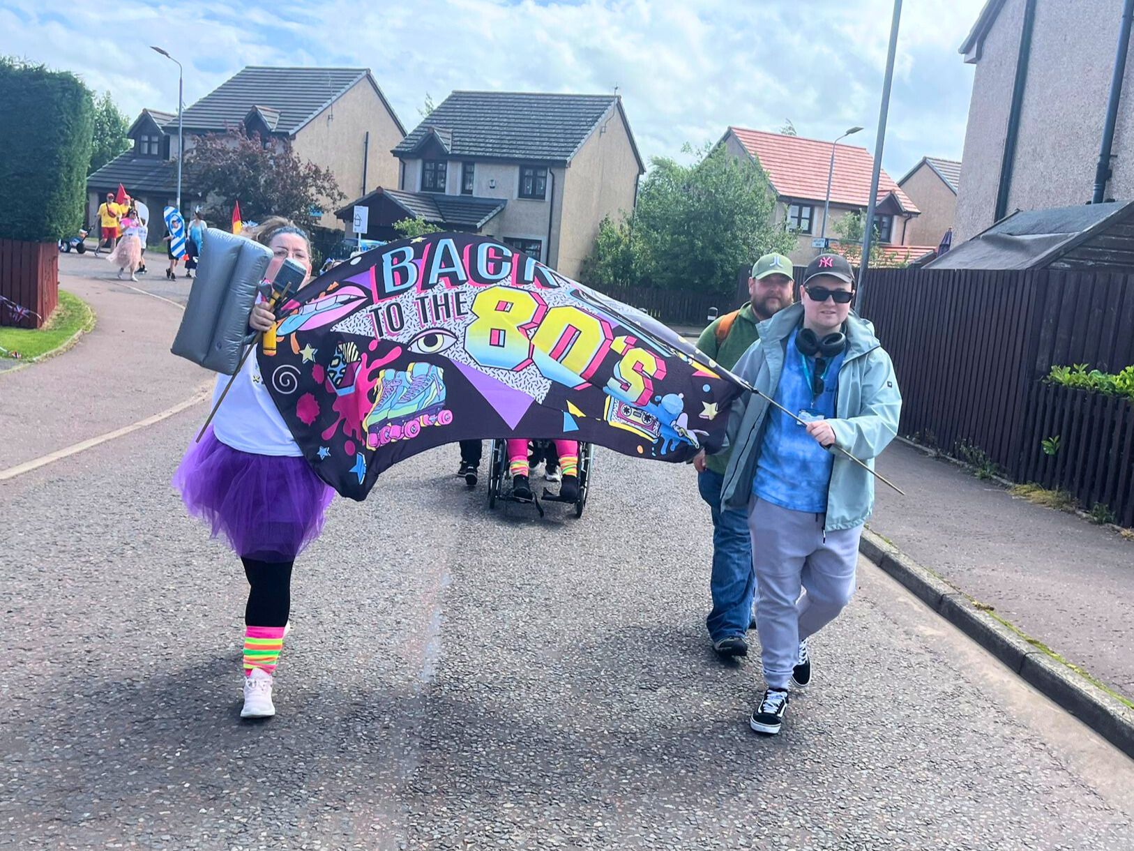 People in 80s costumes carry a