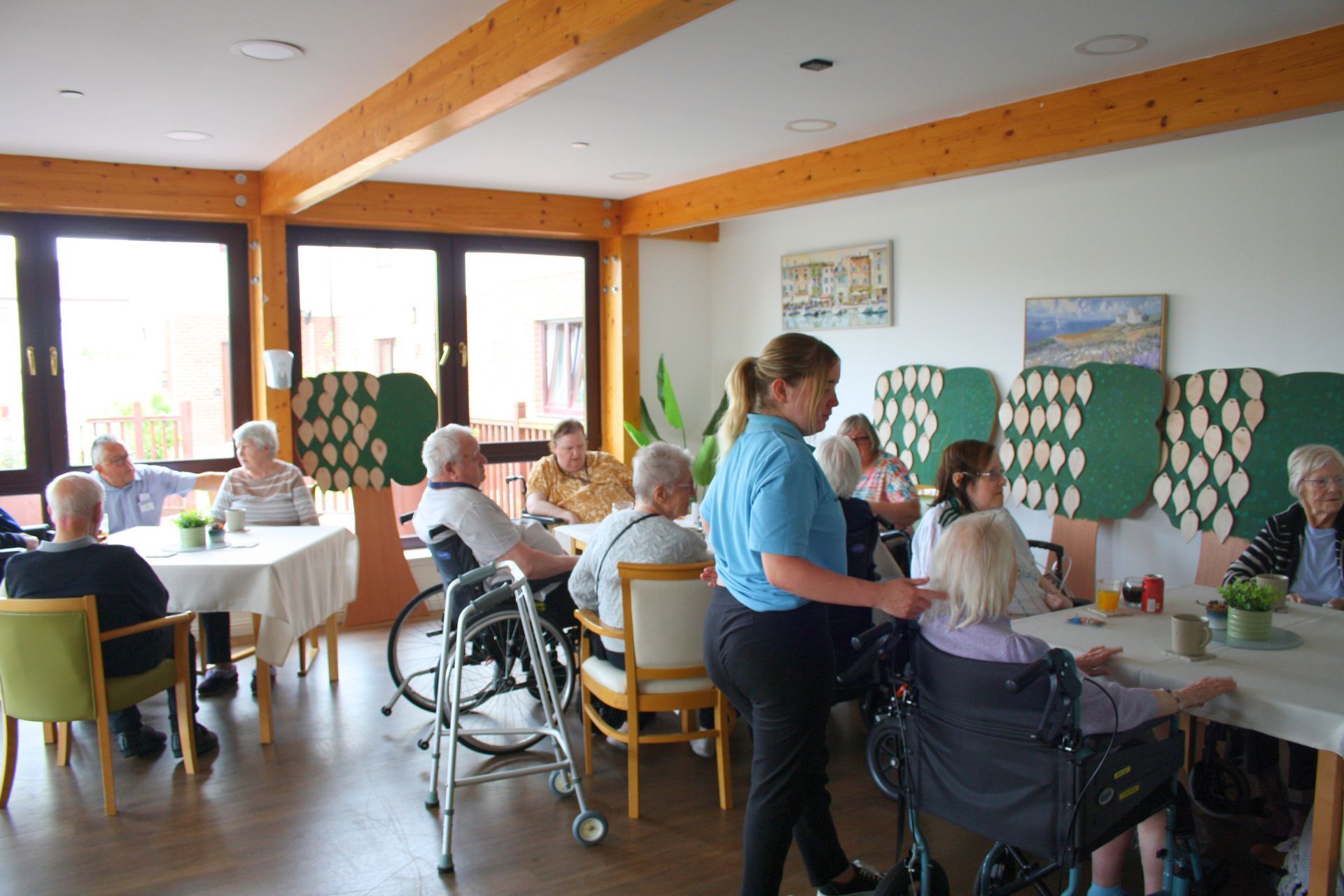 A group of elderly people are sitting at tables in a dining room