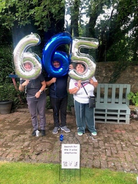 Three people holding giant balloons that spell