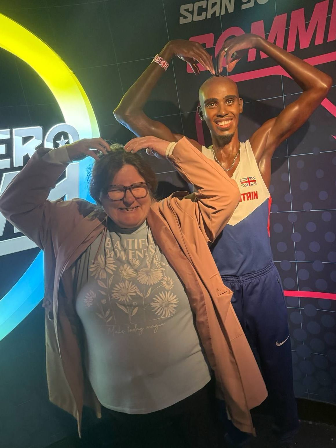 A woman is standing next to a wax figure of a man.