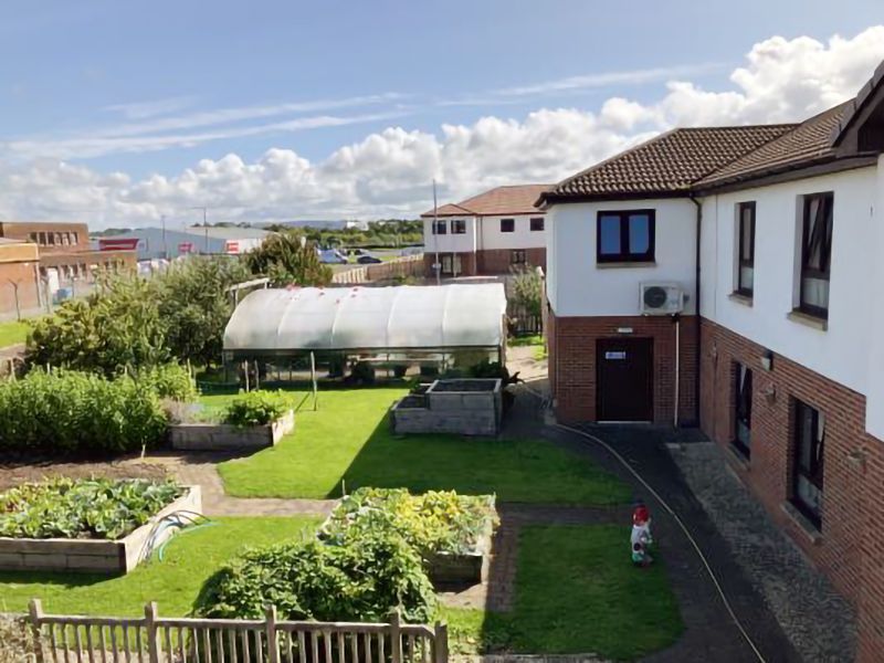 A large building with a greenhouse in the backyard