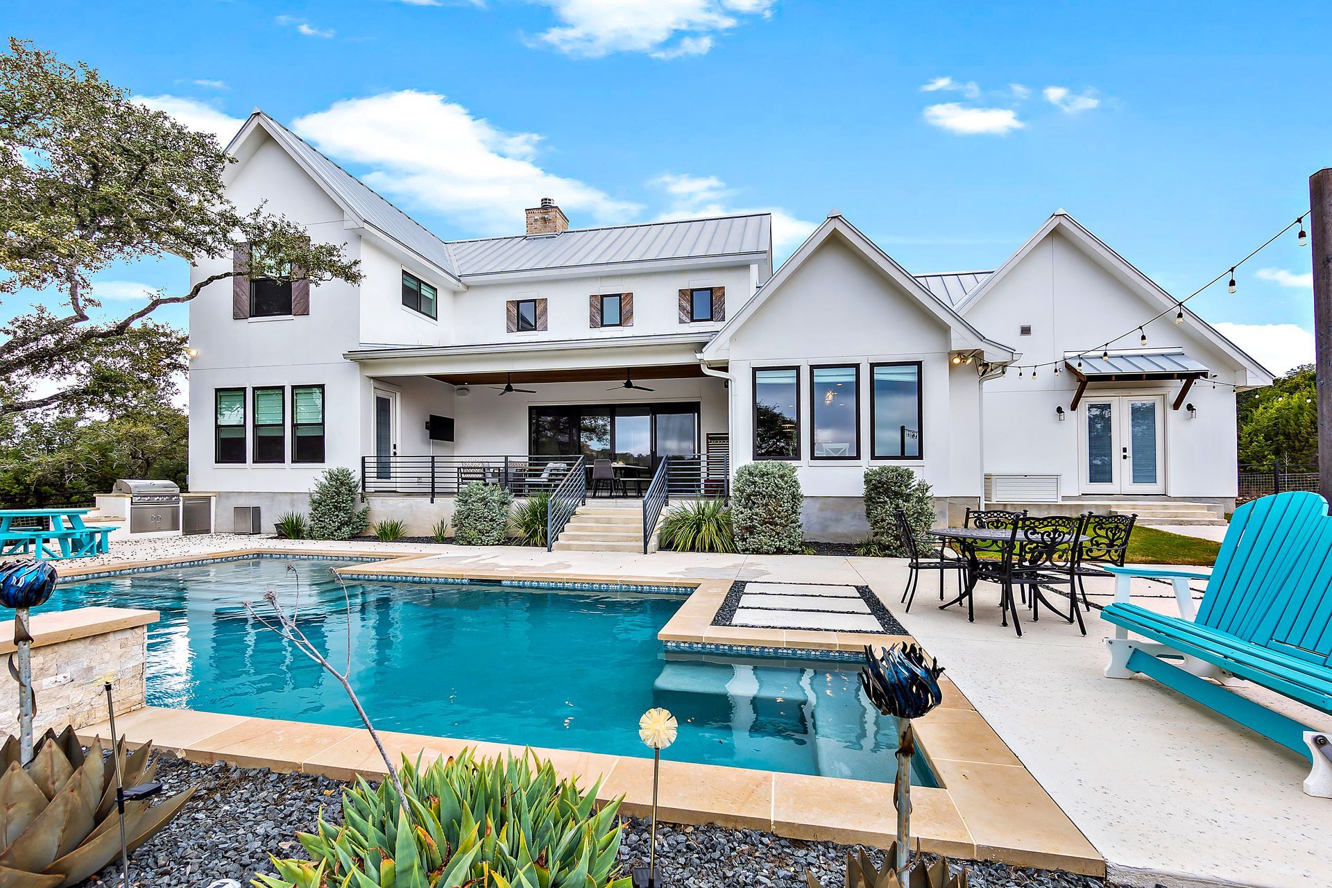 Sleek rectangular pool with spa, lounge chairs, and landscaped greenery.