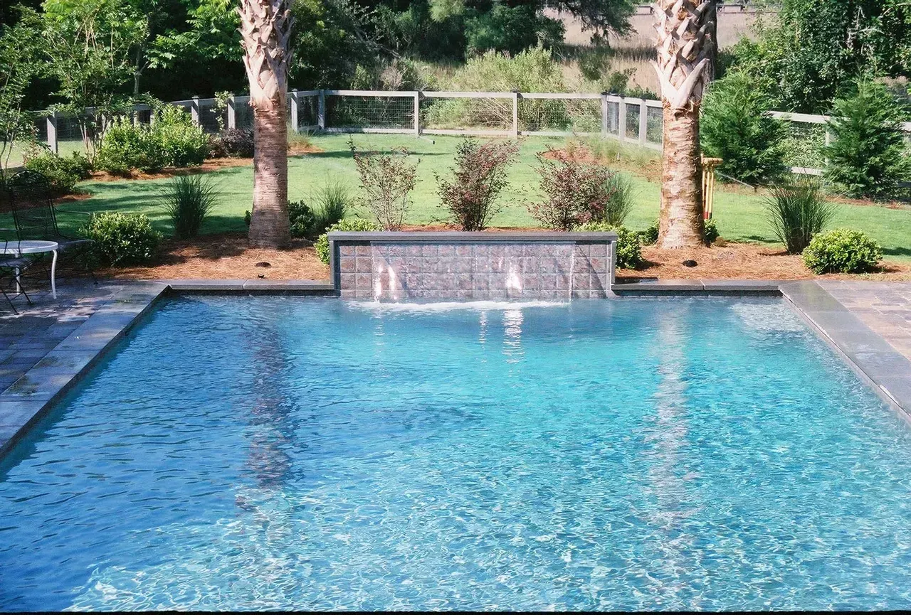A house with a large swimming pool in front of it