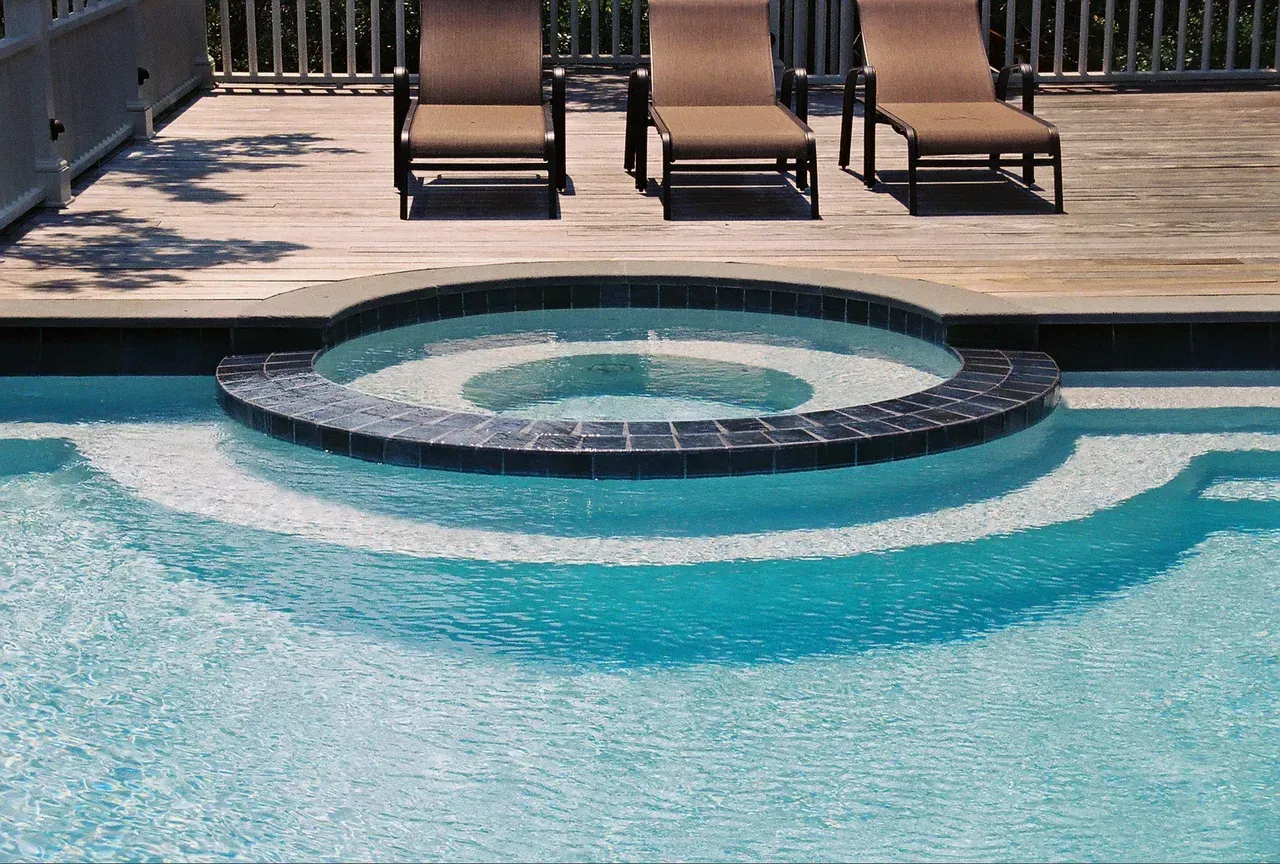 A house with a large swimming pool in front of it