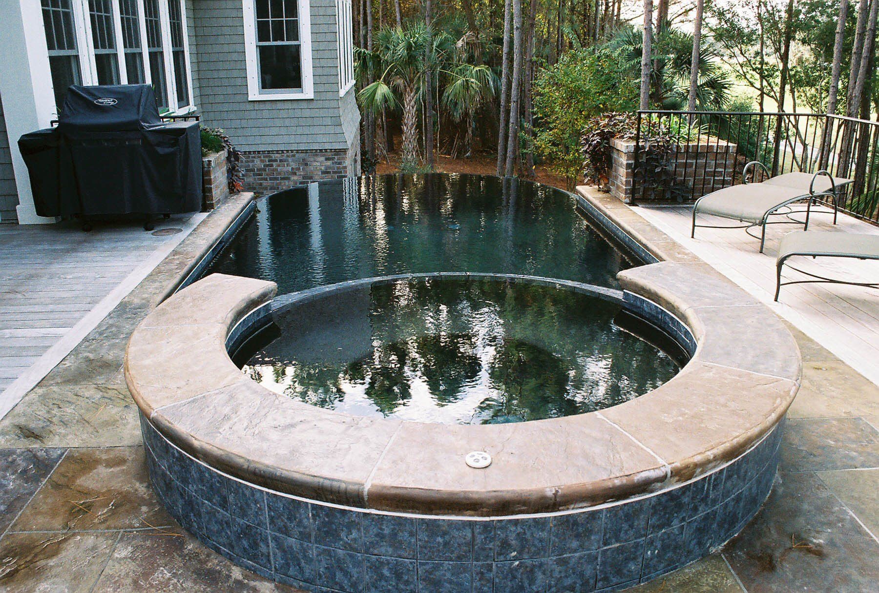 A large swimming pool with a hot tub in the middle