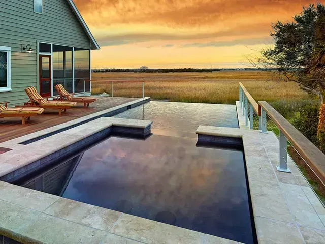 There is a large swimming pool in the backyard of a house.
