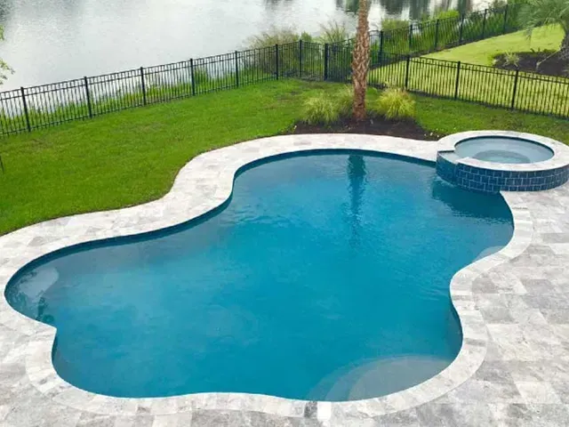 A large swimming pool with a hot tub in the middle of it