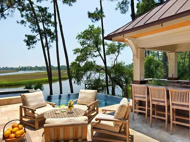 There is a large swimming pool in the backyard of a house.