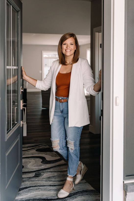 A woman is standing in the doorway of a house.