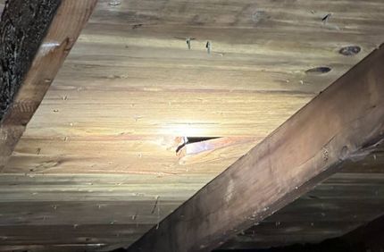 A close up of a wooden ceiling with a hole in it.