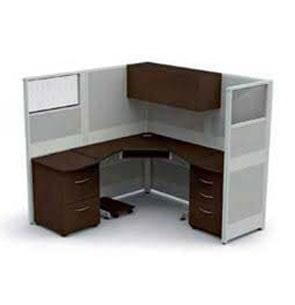 Un cubículo con un escritorio, cajones y una ventana.