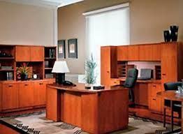 Una oficina de madera con un escritorio, una silla, armarios y una lámpara.