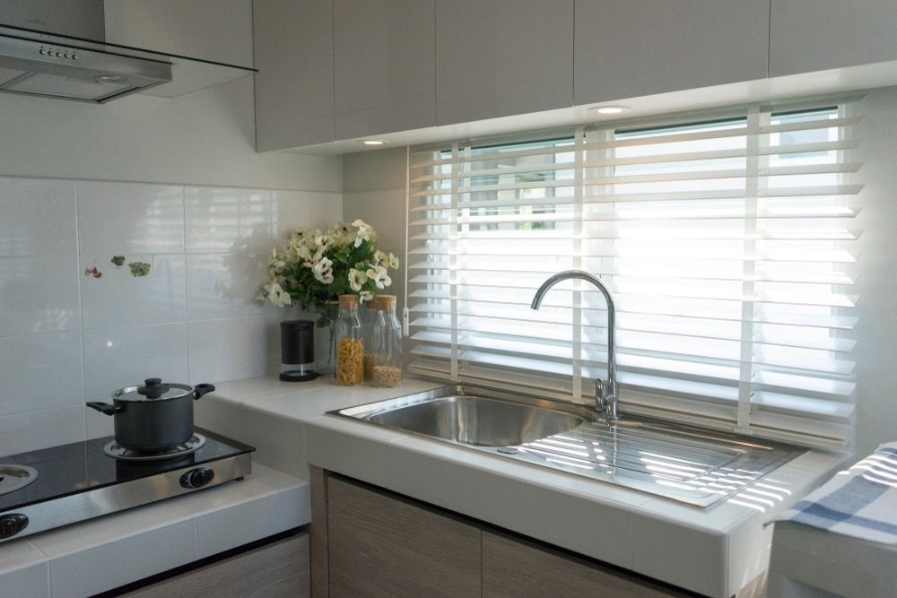 A Kitchen With A Pot On The Stove And A Sink — Ron Ayton Curtains, Blinds & Shutters In Shelly Beach, NSW