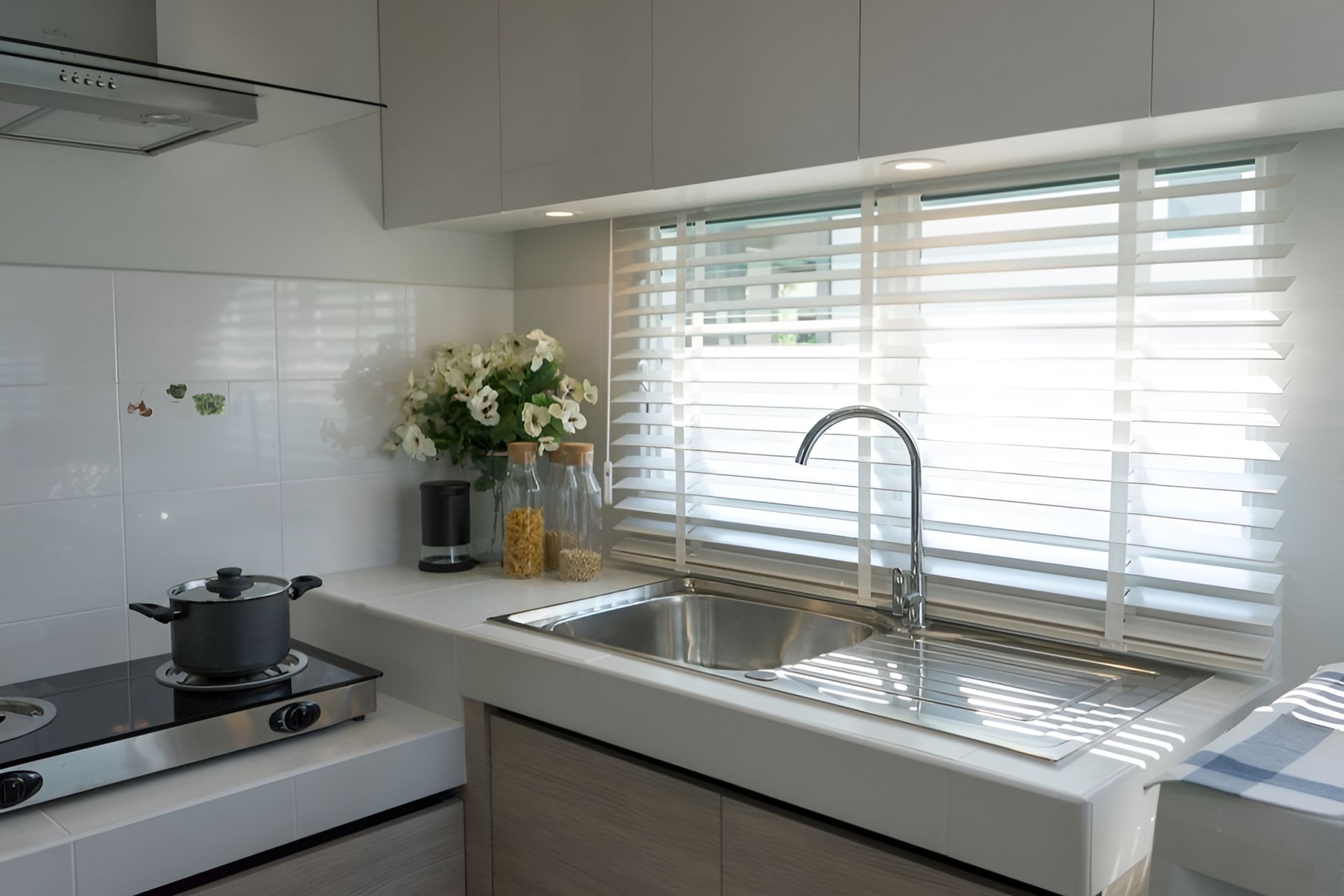 A Kitchen With a Pot on the Stove and a Sink — Ron Ayton Curtains, Blinds & Shutters In Terrigal, NSW
